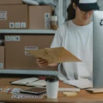 Pekerja logistik menyortir paket di meja kerja gudang pengiriman